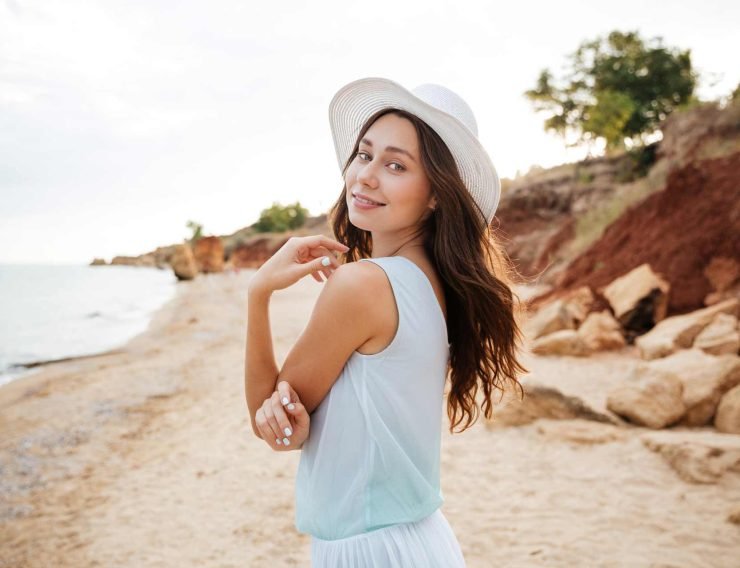 happy-young-woman-in-white-hat-waalking-near-the-PMPGEFG.jpg